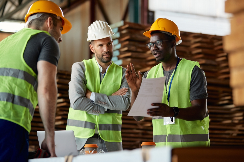African-American worker and his colleagues talking to warehouse inspector